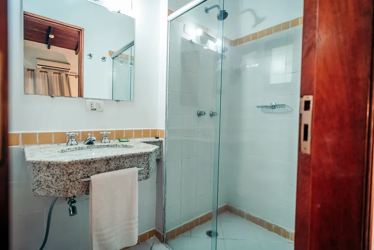Banheiro da Suíte Junior com box de vidro e bancada de granito