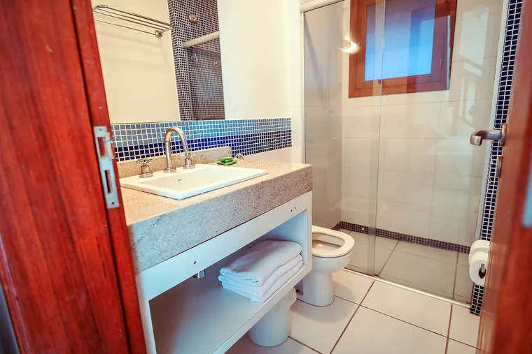 Banheiro da Suíte com Varanda, com pastilhas azuis e box de vidro