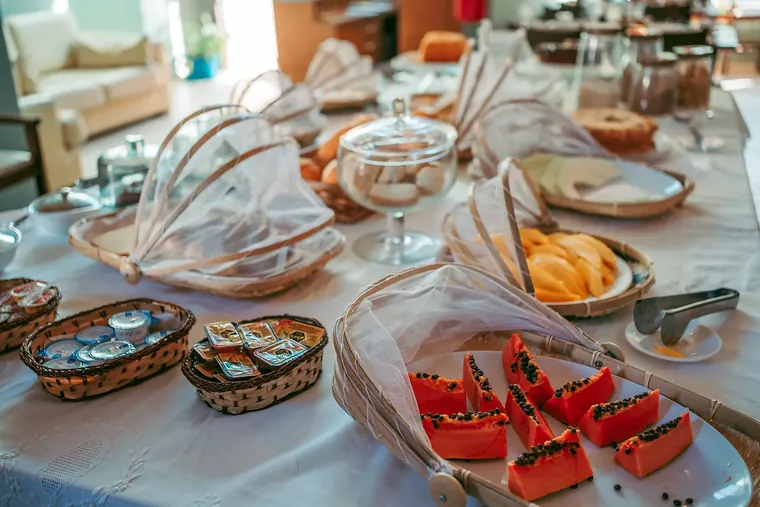 Mesa do café com mamão, melão, iogurtes e bolos