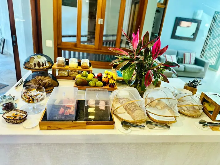 Mesa do café da manhã da Pousada Brigitte com bolos, frutas, pães e frios