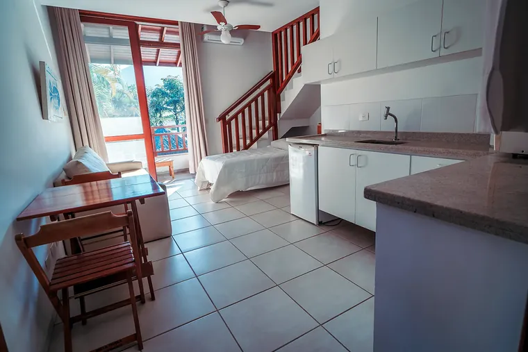 Estúdio com mini cozinha, sala e escada