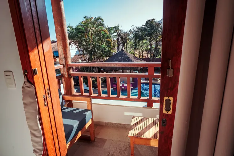Varanda do Estúdio Família com sofá e vista para a piscina