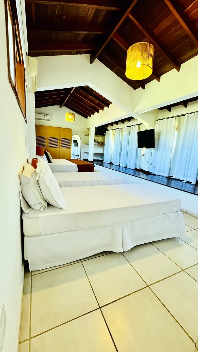 Varanda do estúdio com cortinas brancas e vista para a piscina e a serra