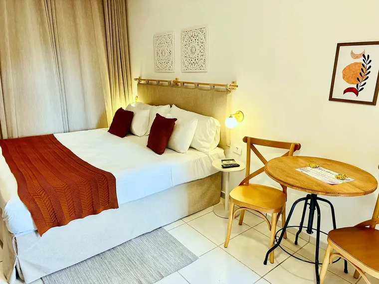 Cama do Estúdio Varanda com cabeceira de linho e mesa para dois