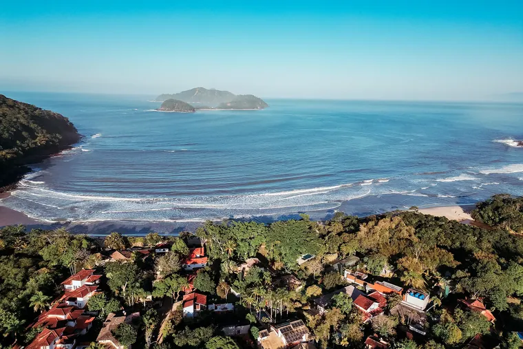 Vista aérea da enseada da Barra do Sahy com a ilha ao largo e as casas na mata