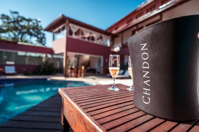 Taças e balde de espumante no deck da piscina