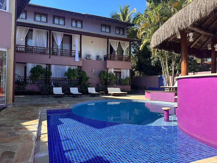 Piscina da Vila Bardot com bar rosa e banquetas dentro da água
