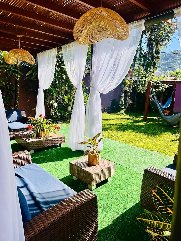 Lounge por dentro, com rede e a serra ao fundo